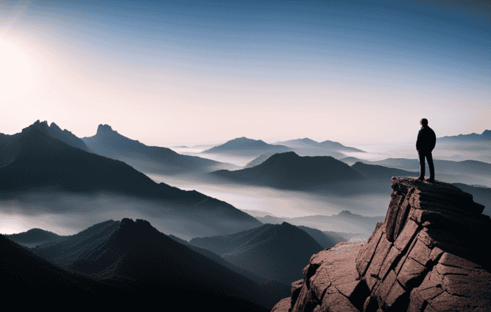 An image of a person standing alone on top of a mountain, looking out at a vast and beautiful landscape